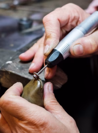 jeweler-polishes-gold-ring-on-old-workbench-in-jewelry-workshop